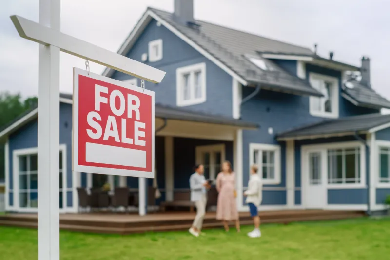 For sale sign in front of house